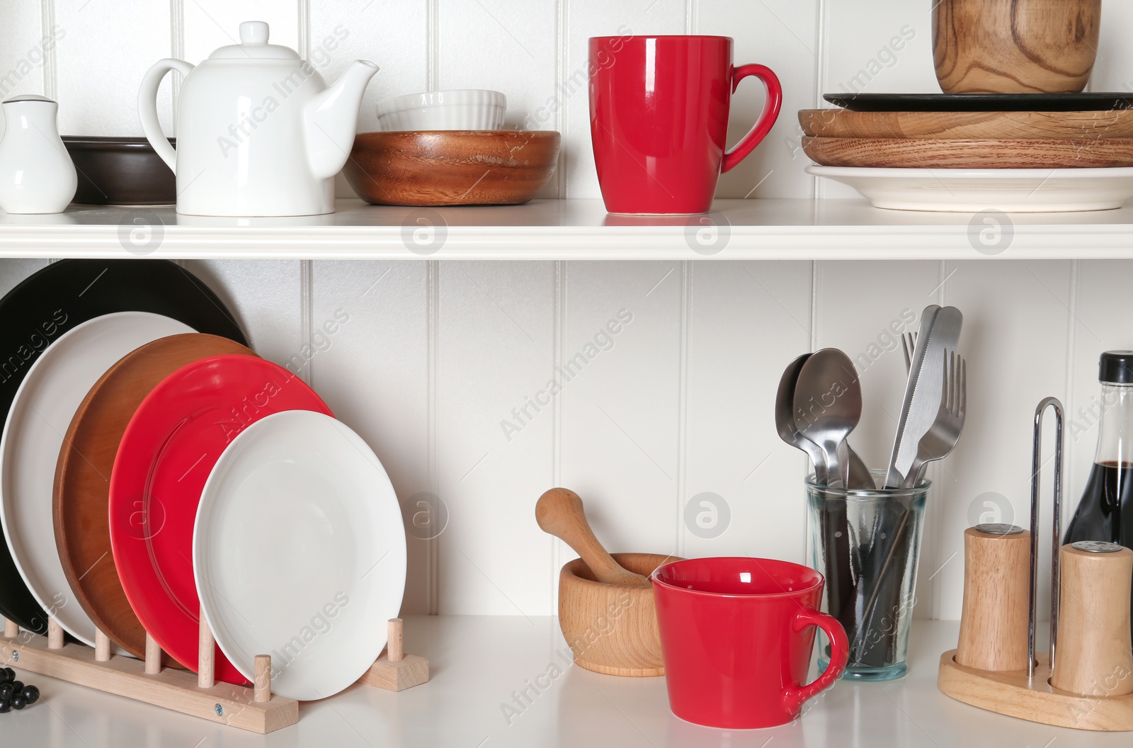 Photo of White shelving unit with set of dishware