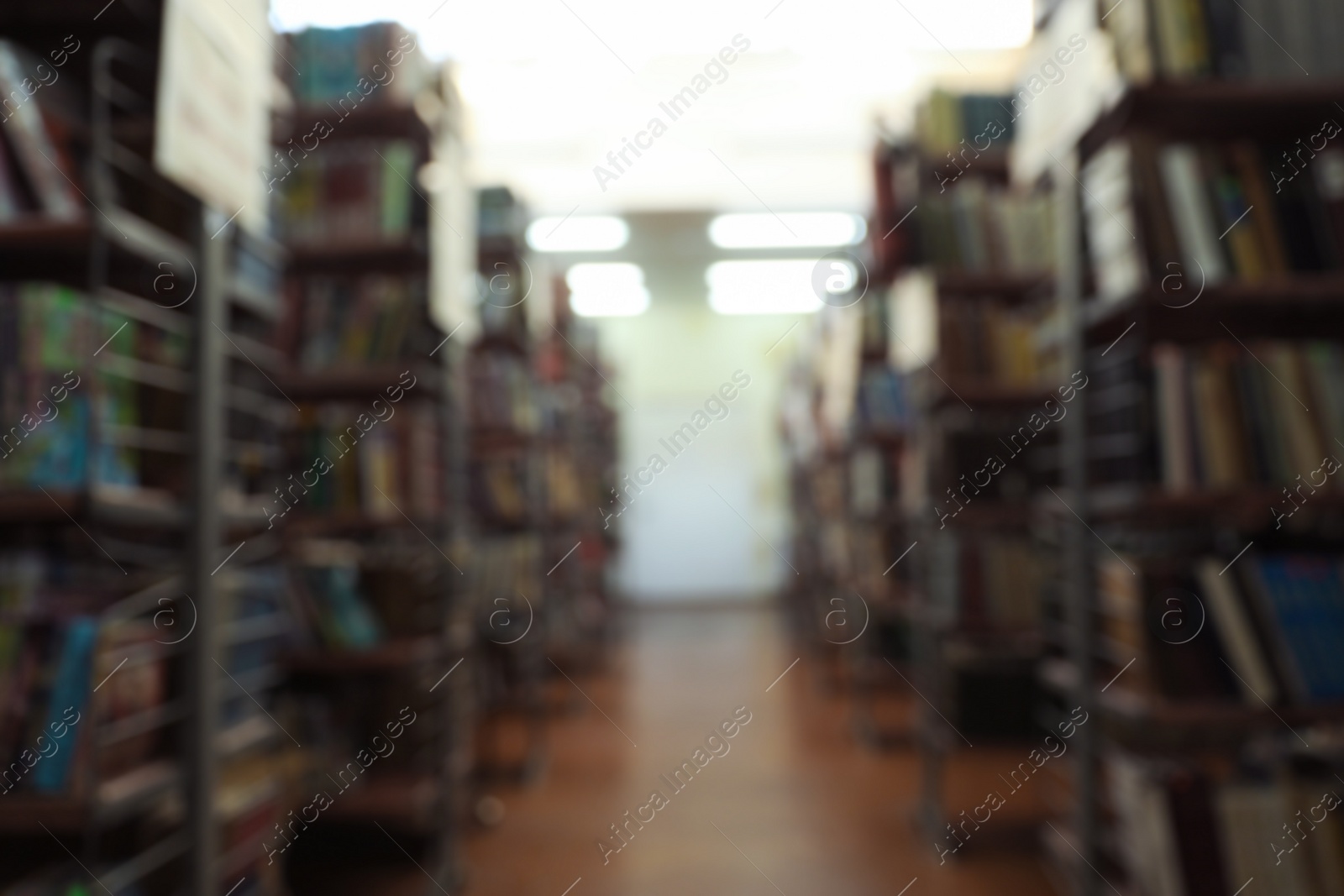 Photo of Blurred view of shelving units with books in library