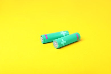 Photo of New AA size batteries on yellow background