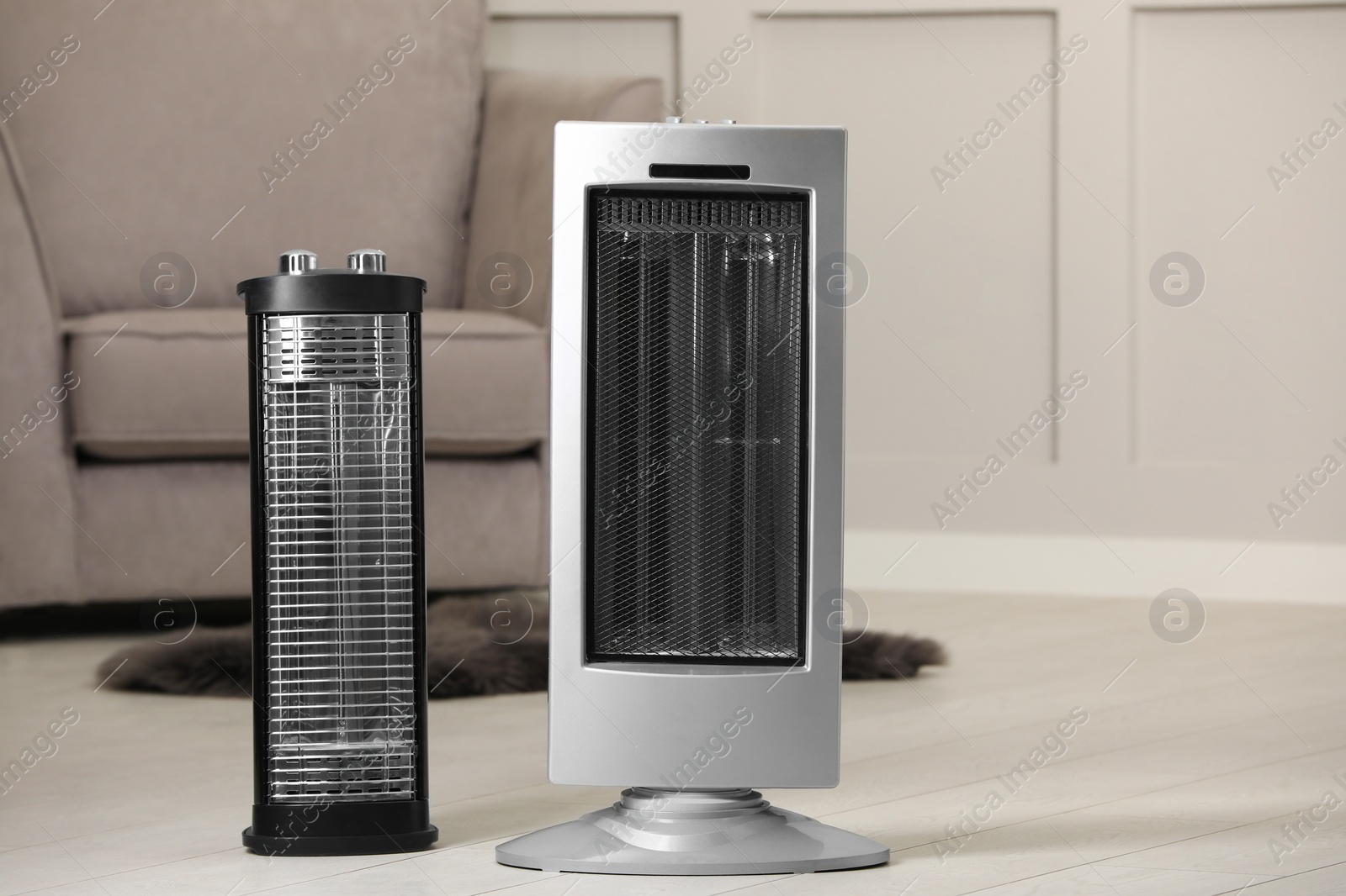 Photo of Different modern infrared heater on floor in cozy room