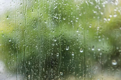 Photo of Window glass with water drops, closeup. Rainy weather