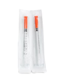 Packed disposable syringes on white background, top view