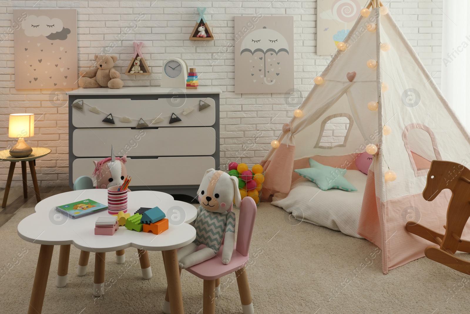 Photo of Cute child's room interior with toys and play tent