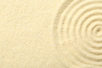 Photo of Zen rock garden. Circle pattern on beige sand, top view