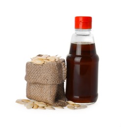 Photo of Fresh pumpkin seed oil in bottle and bag of kernels isolated on white