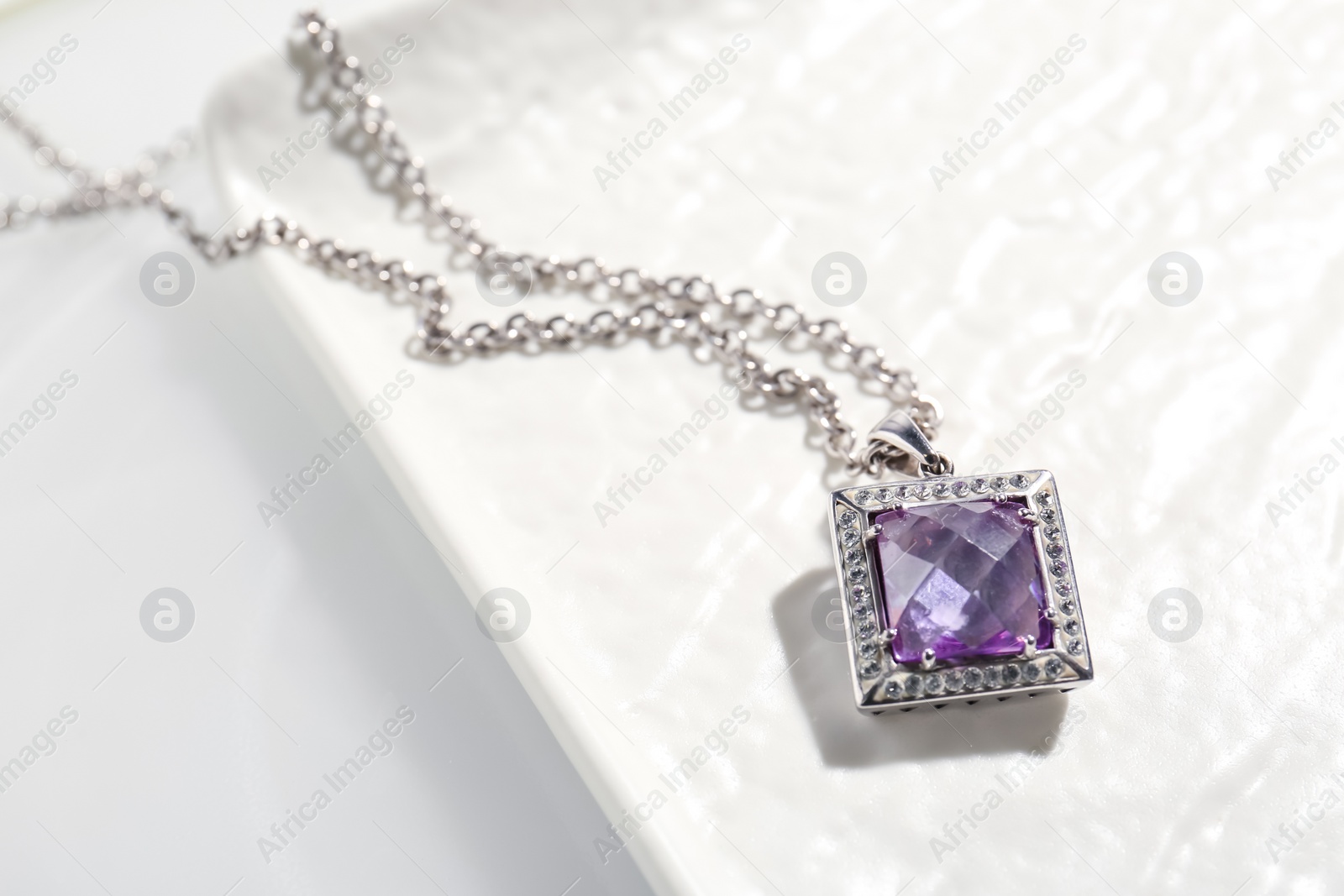 Photo of Beautiful necklace with gemstone on white table, above view