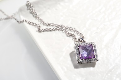 Photo of Beautiful necklace with gemstone on white table, above view