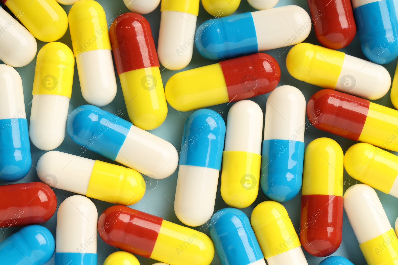 Photo of Many antibiotic pills on light blue background, top view