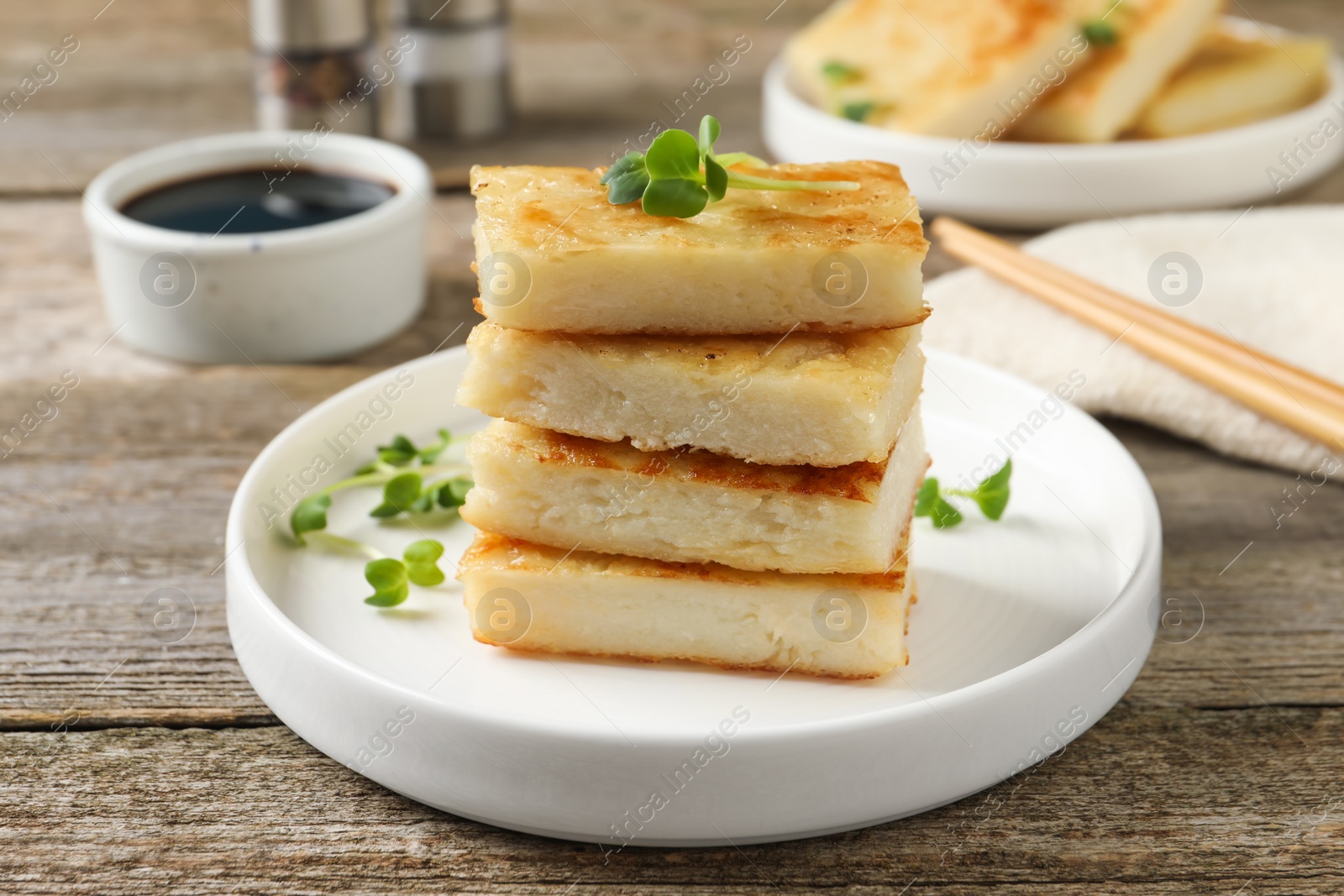 Photo of Delicious turnip cake with microgreens served on wooden table