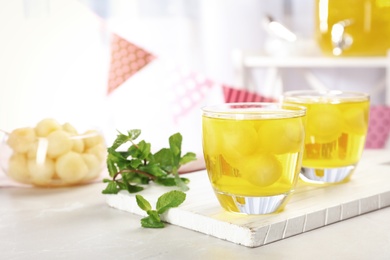 Photo of Glasses with tasty melon ball drink on light table