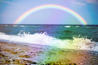 Image of Beautiful view of colorful rainbow in sky over sea