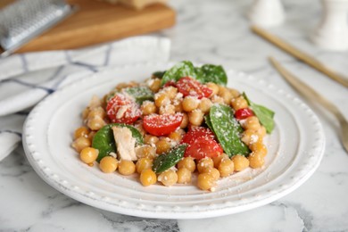 Photo of Delicious fresh chickpea salad on white marble table