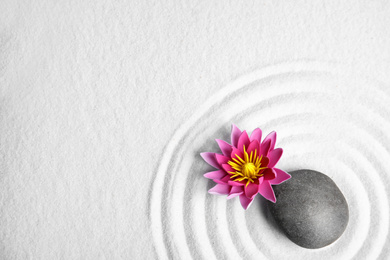 Photo of Zen garden. Beautiful lotus flower, stone and space for text on white sand, flat lay