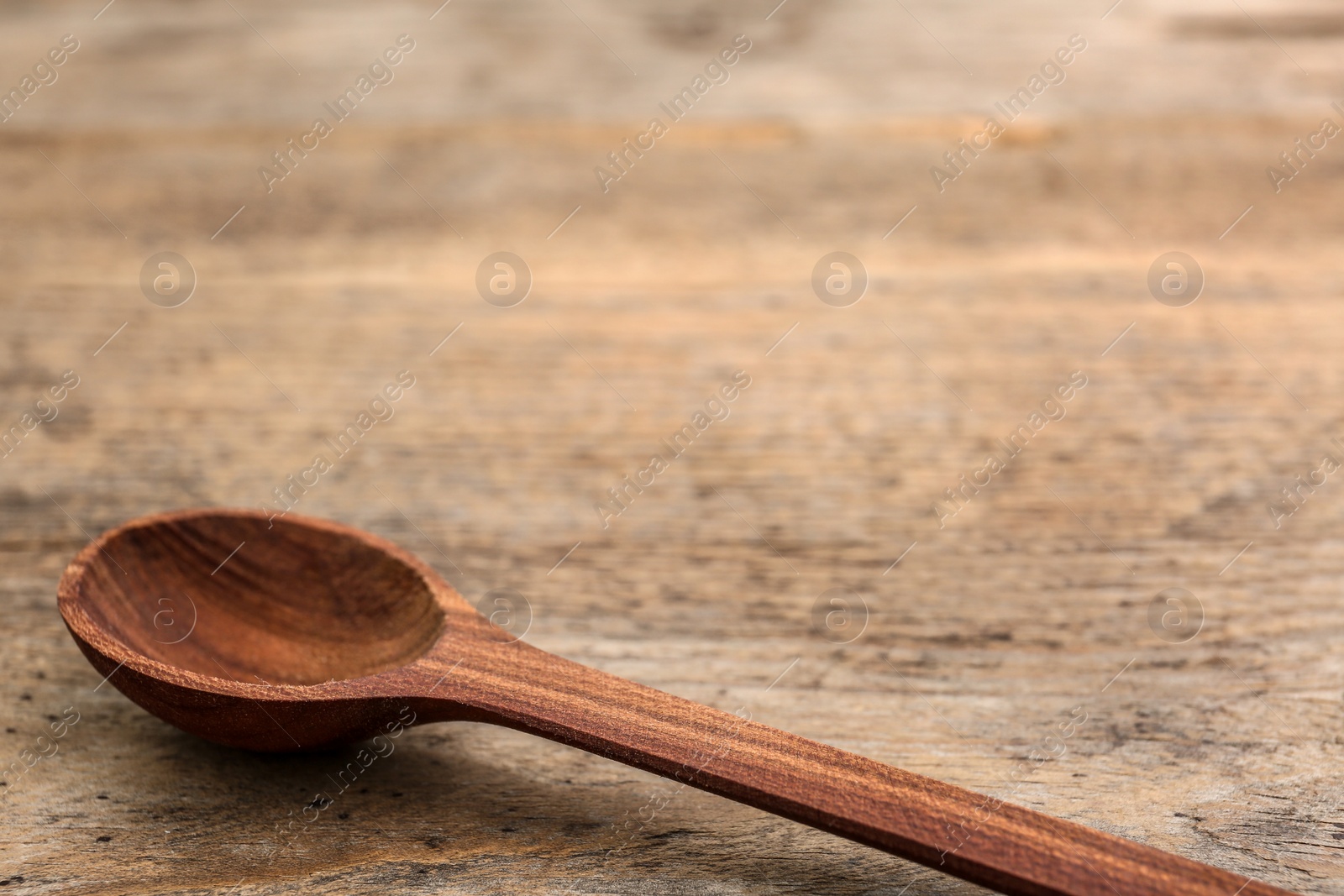 Photo of Clean spoon and space for text on wooden background