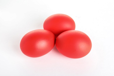 Photo of Red dyed Easter eggs on white background