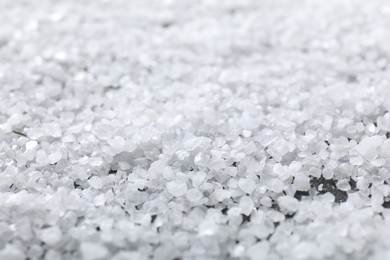 White natural salt as background, closeup view