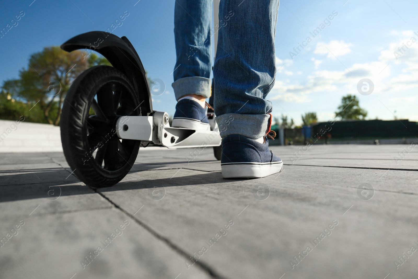 Photo of Man with kick scooter on city street, closeup