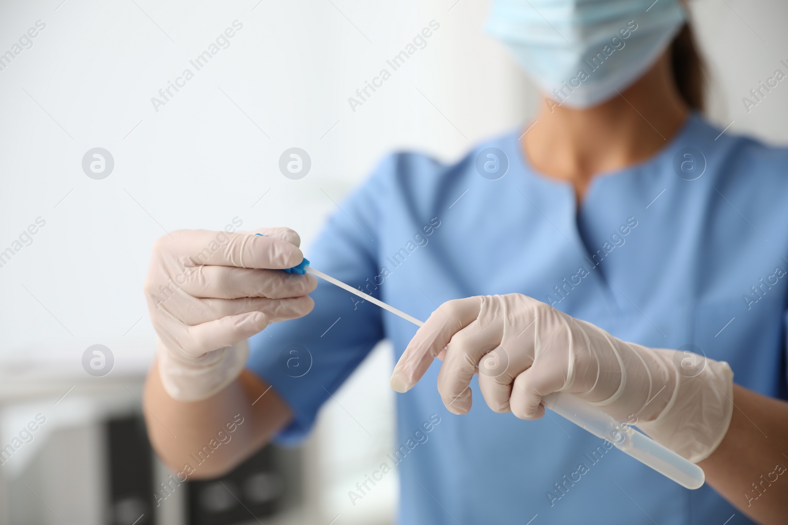 Photo of Doctor holding buccal cotton swab and tube for DNA test in clinic, closeup