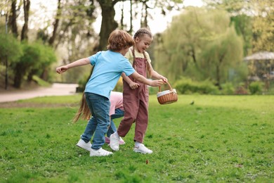 Easter celebration. Cute little children hunting eggs outdoors