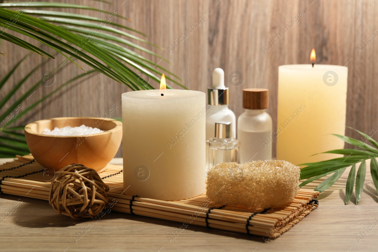 Photo of Composition with spa supplies and palm leaves on wooden table