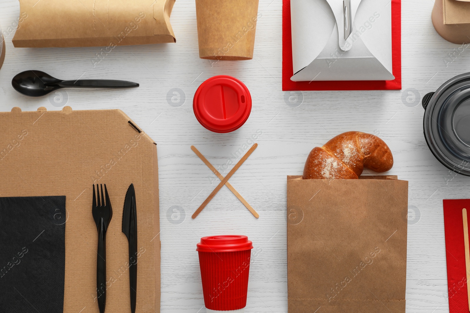 Photo of Flat lay composition with paper bag and different takeaway items on wooden background. Space for design