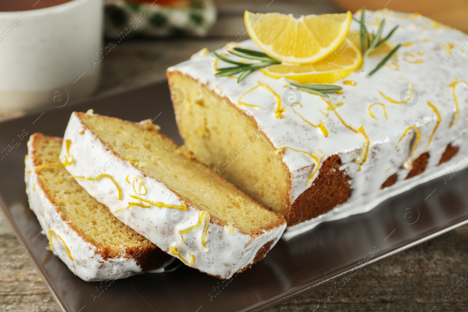 Photo of Tasty lemon cake with glaze on wooden table, closeup