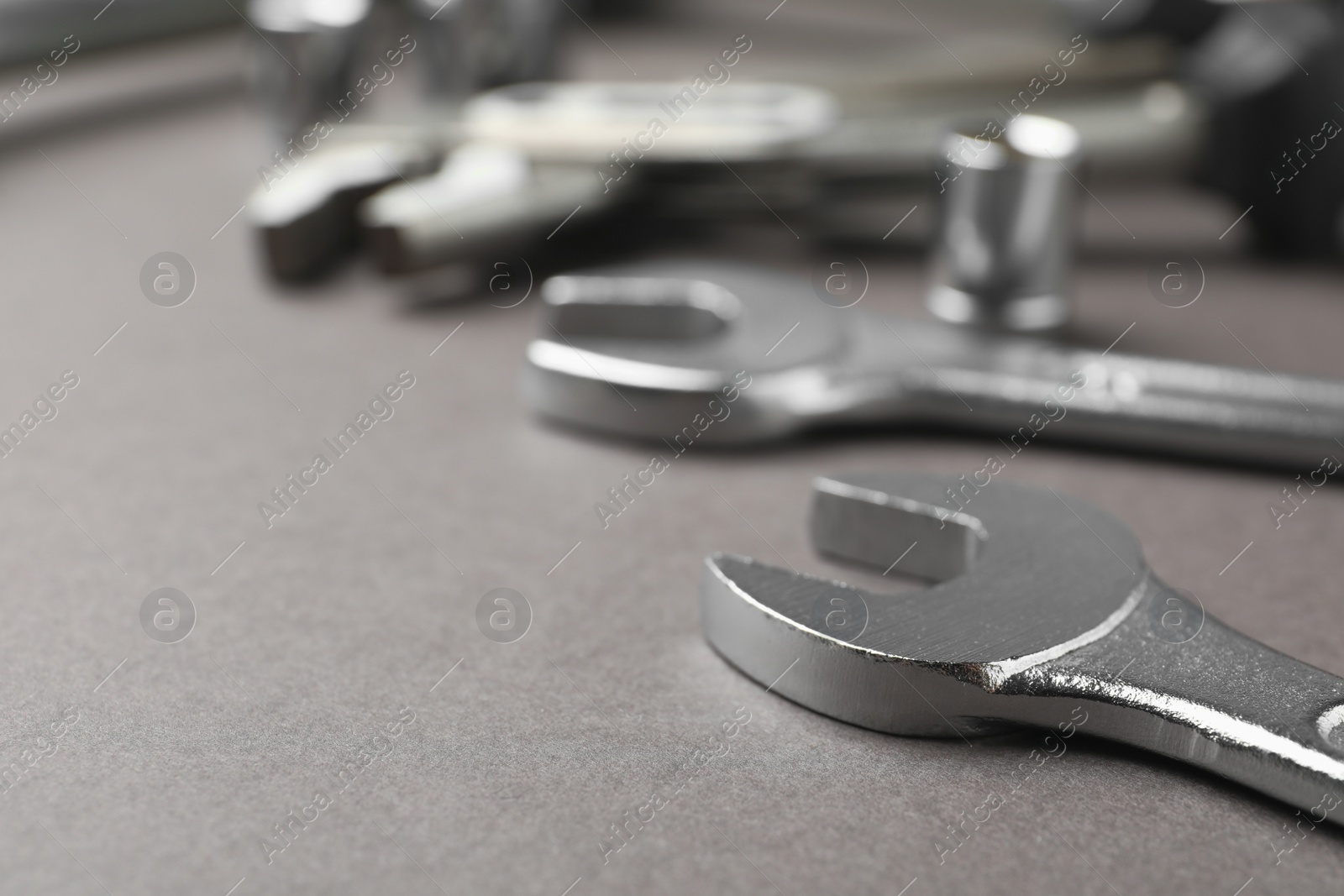 Photo of Auto mechanic's tools on grey background, closeup. Space for text