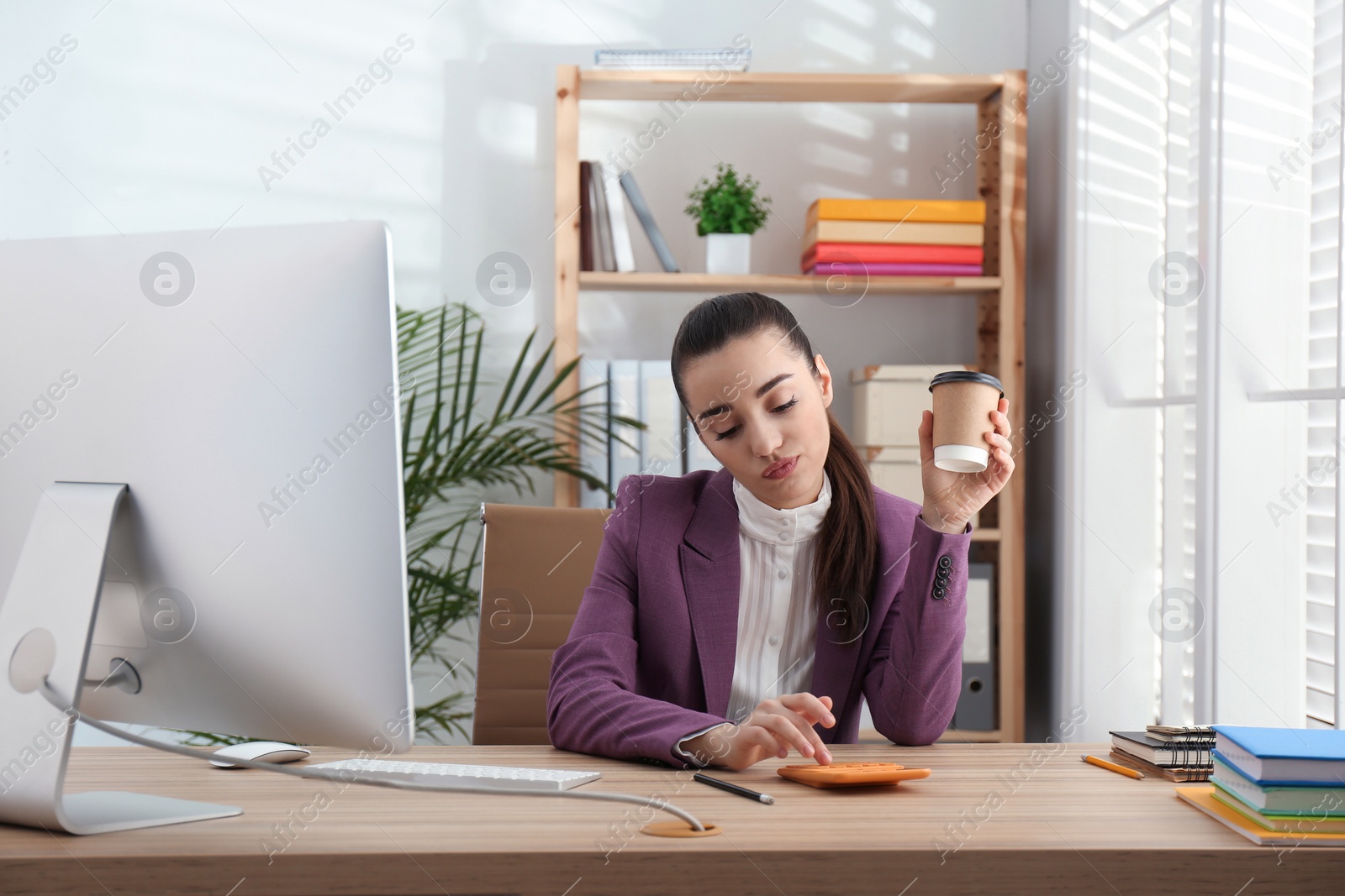 Photo of Lazy employee drinking coffee at table in office