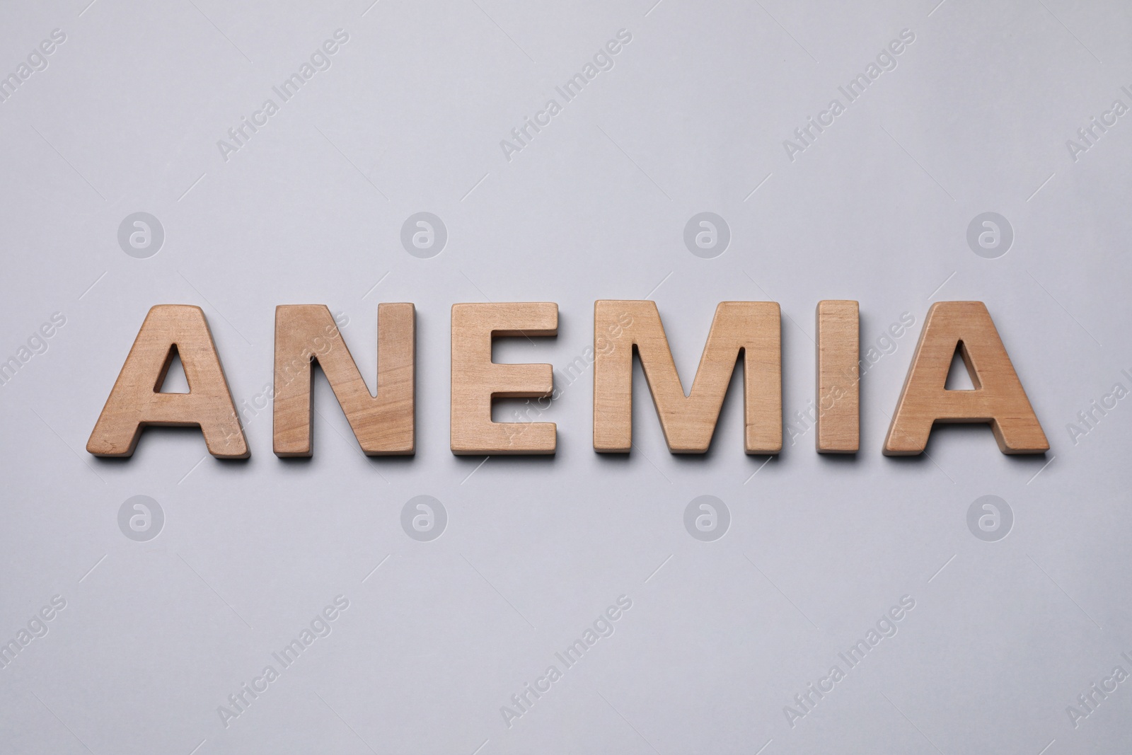 Photo of Word Anemia made of wooden letters on grey background, flat lay