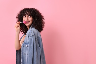 Photo of Beautiful woman with lollipop on pink background, space for text