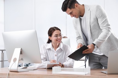 Businessman helping intern with work in office