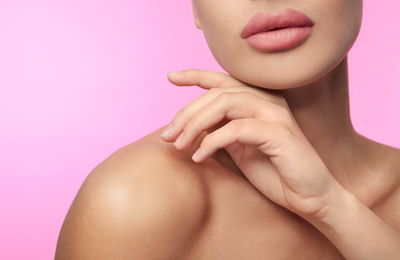 Woman with matte lipstick on pink background, closeup
