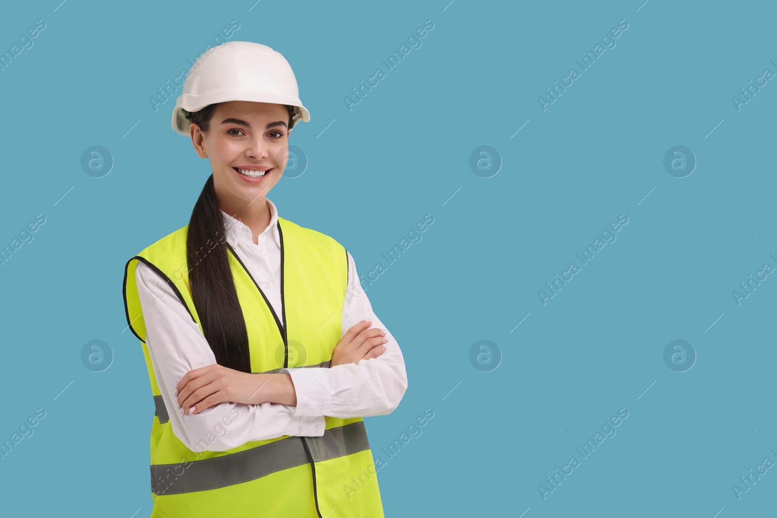 Photo of Engineer in hard hat on light blue background, space for text