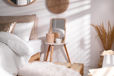 Stylish nightstand near bed in modern room interior