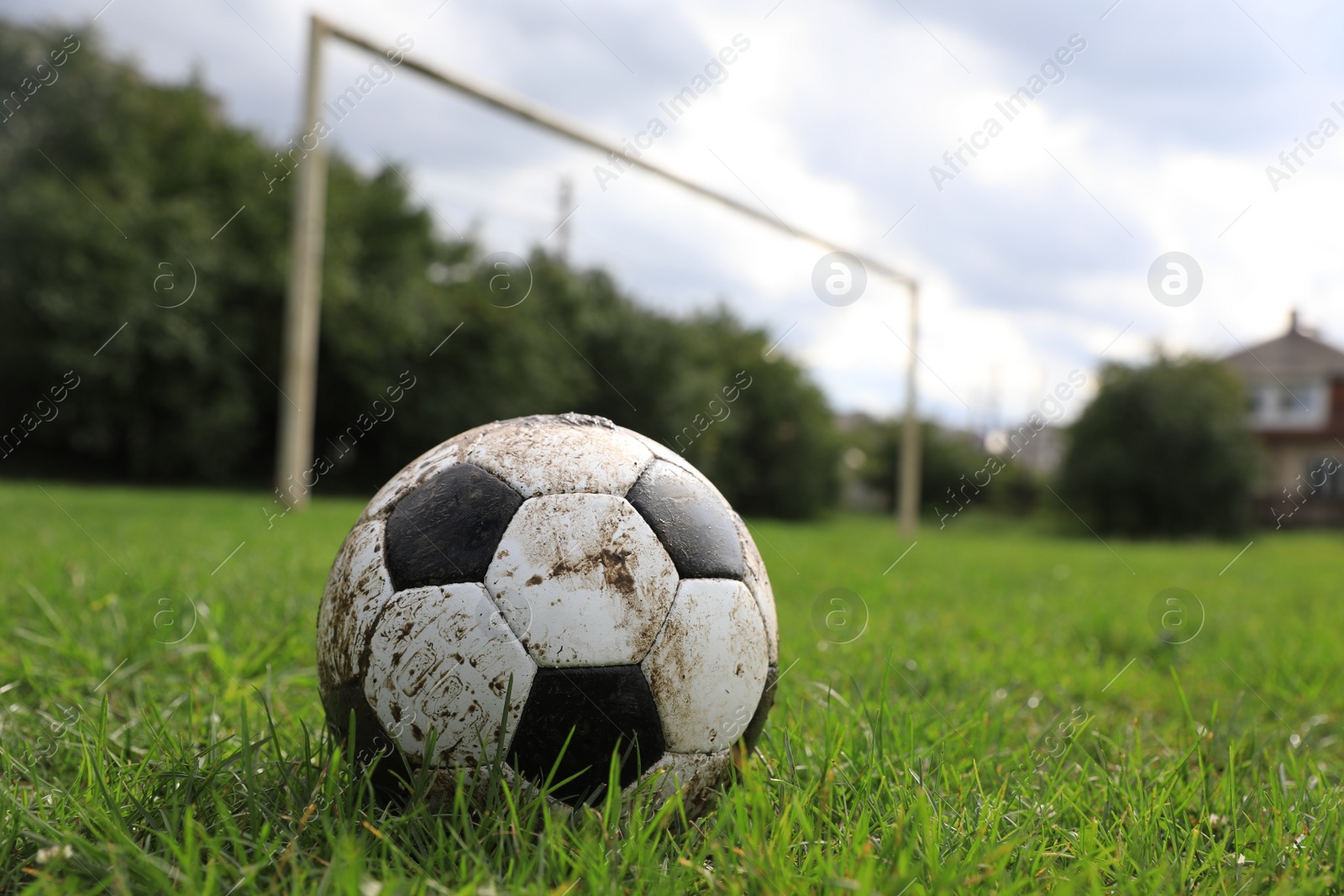 Photo of Dirty soccer ball on green grass outdoors, space for text