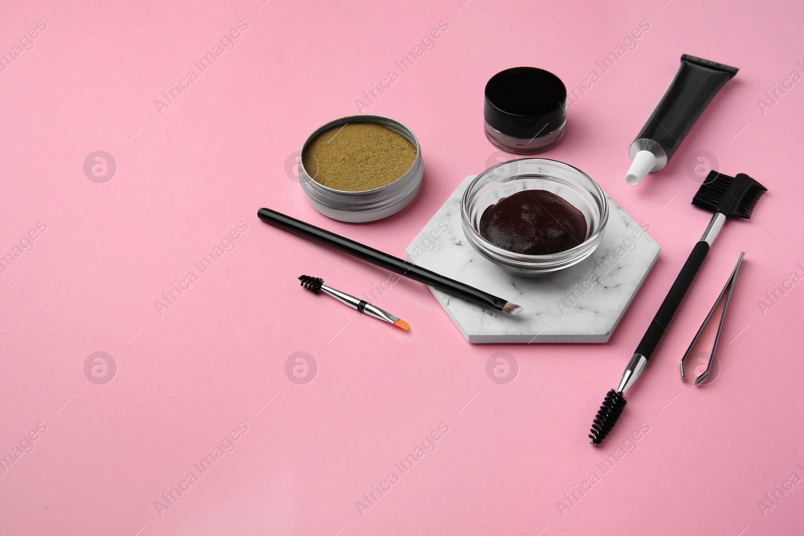 Photo of Eyebrow henna and tools on pink background. Space for text