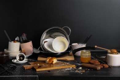 Photo of Messy countertop with many dirty utensils, dishware and food leftovers in kitchen