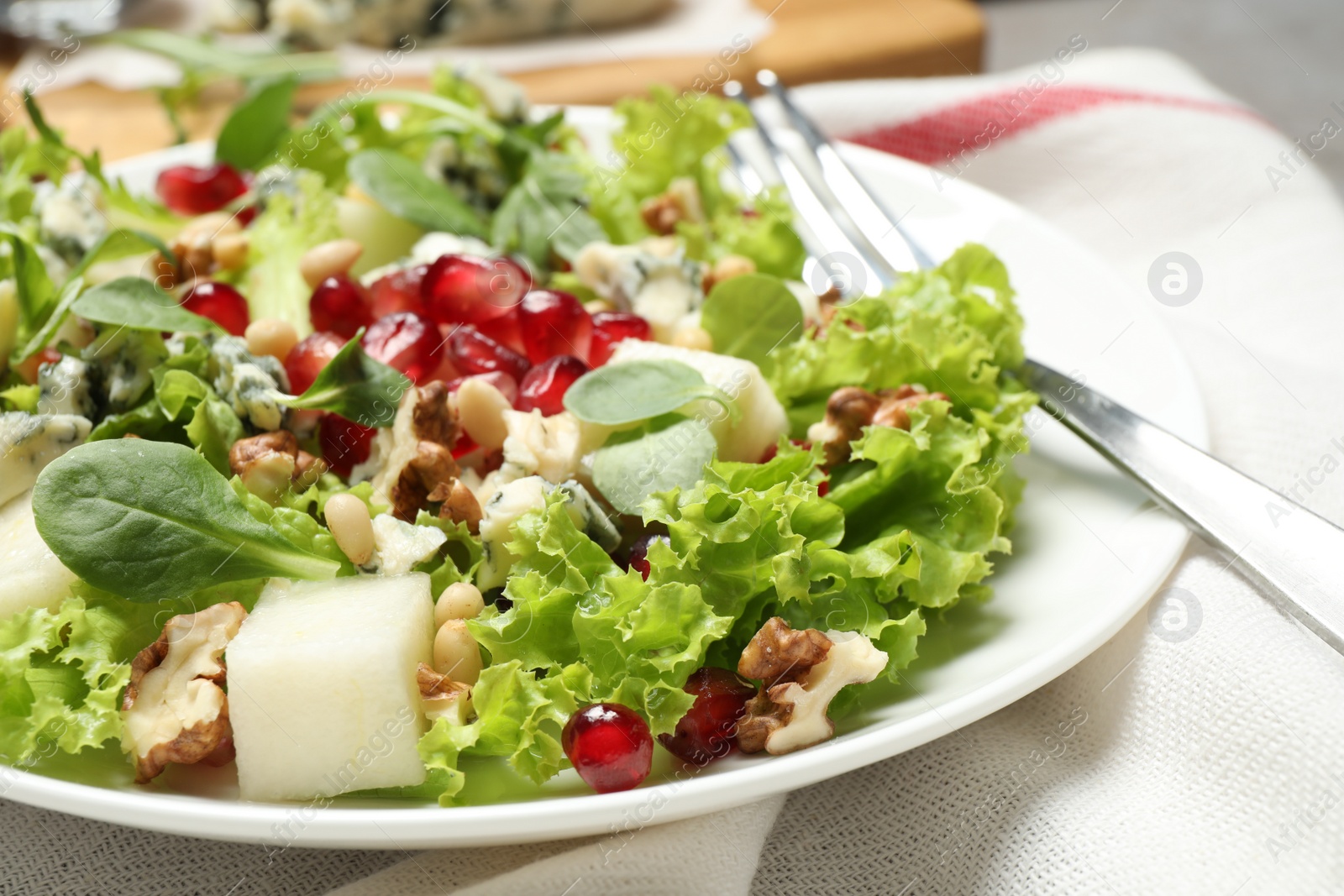 Photo of Fresh salad with pear on table, closeup