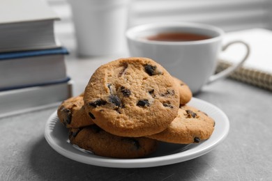 Chocolate chip cookie on light grey table in office, closeup