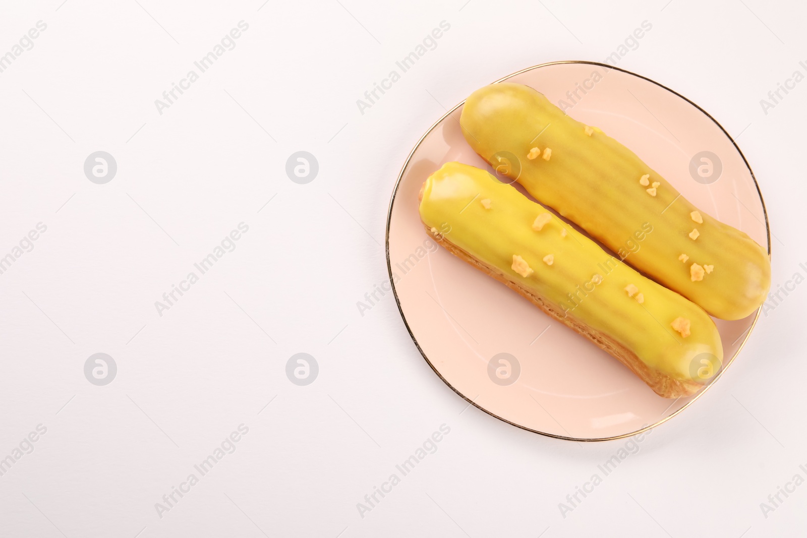 Photo of Delicious eclairs covered with glaze on white background, top view