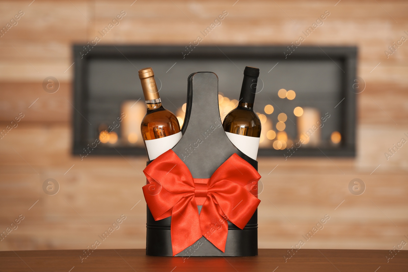 Photo of Festive package with bottles of wine on table in room