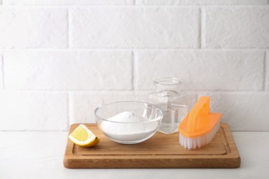 Photo of Baking soda, lemon and vinegar on white table. Eco friendly detergents