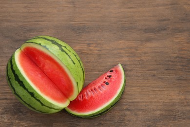 Delicious cut watermelons on wooden table, above view. Space for text