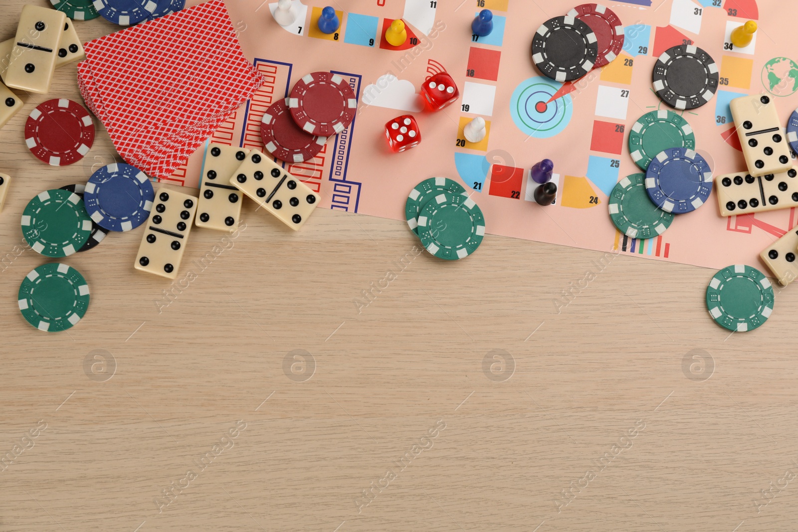 Photo of Elements of different board games on wooden table, flat lay. Space for text
