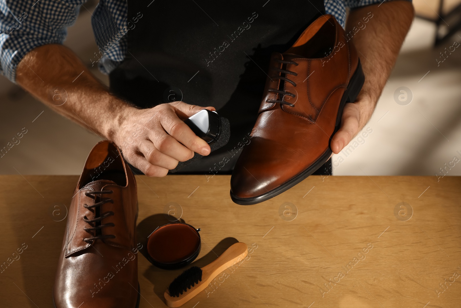 Photo of Master taking care of shoes in his workshop, closeup