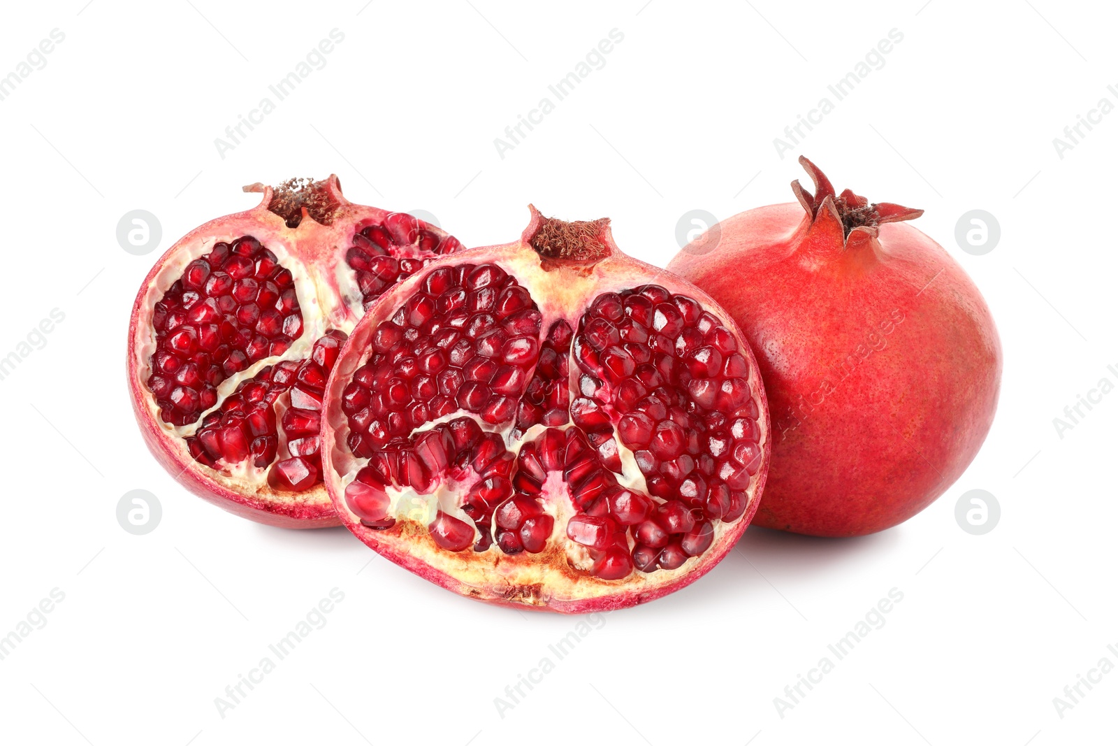 Photo of Halves and whole pomegranates isolated on white