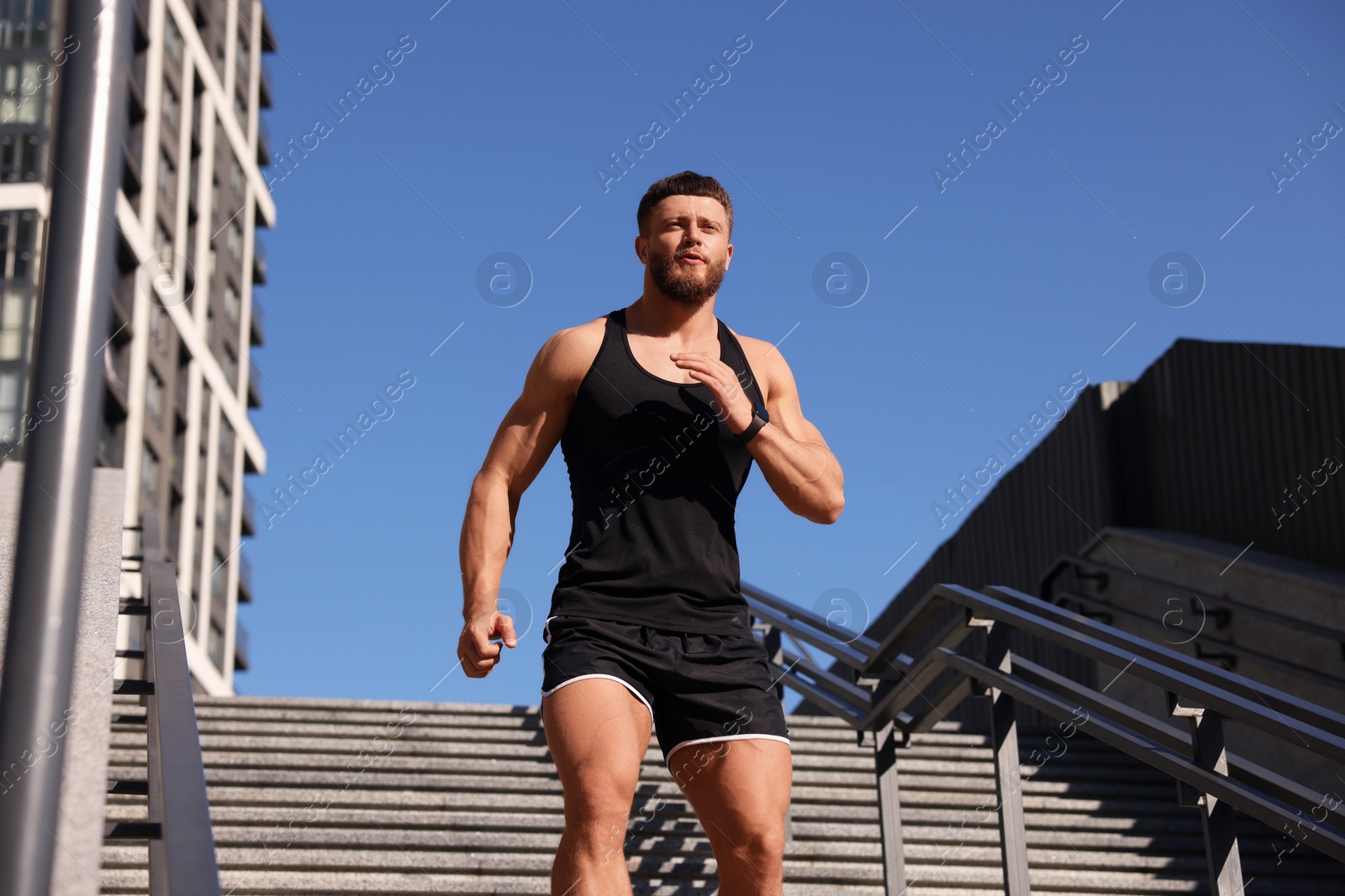 Photo of Man running down stairs outdoors on sunny day