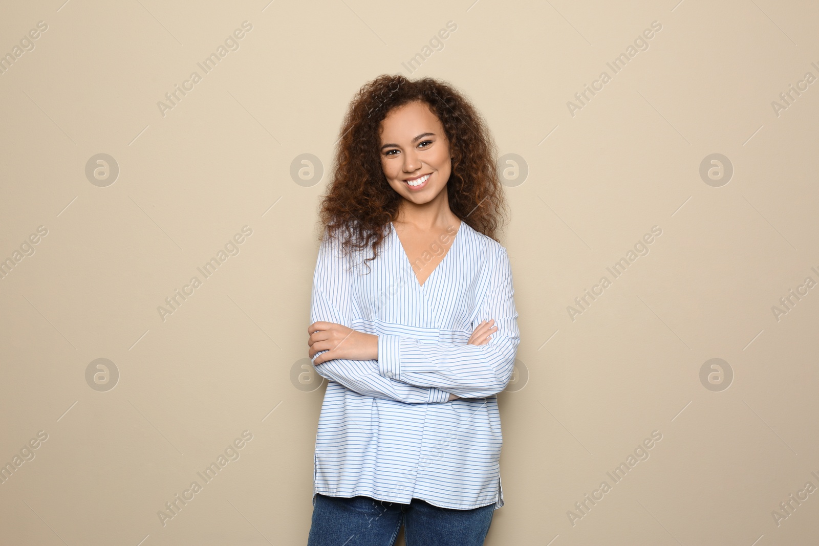 Photo of Young African-American woman with beautiful face on beige background