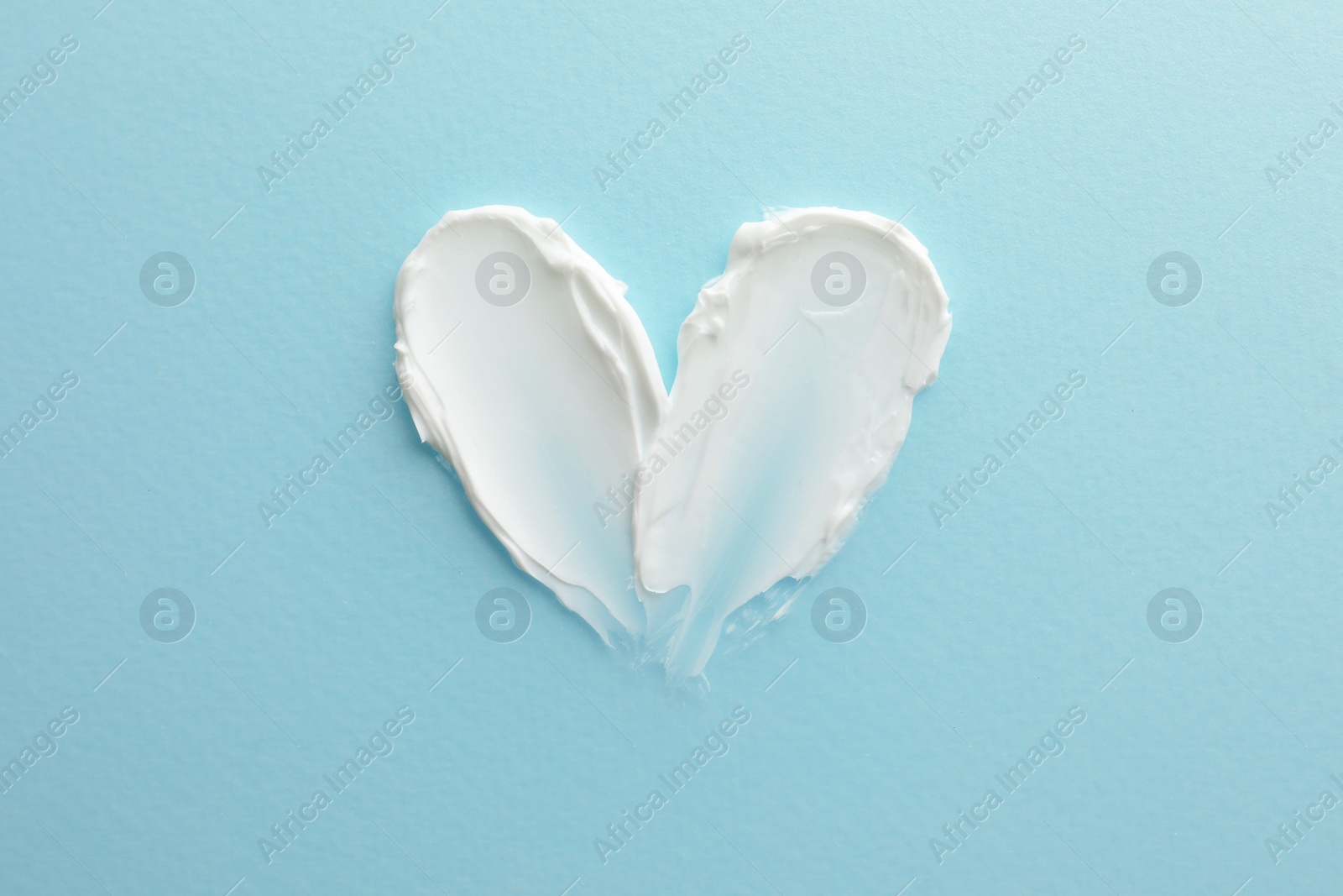 Photo of Sample facial cream on turquoise background, top view