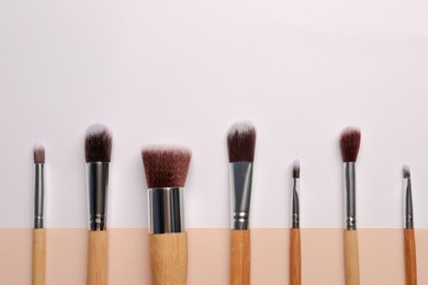 Photo of Set of makeup brushes on color background, flat lay. Space for text
